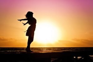 a woman on the beach experiencing well-being