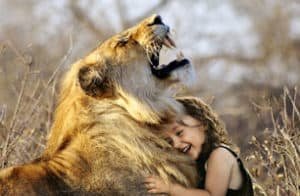 A girl laughing with a lion