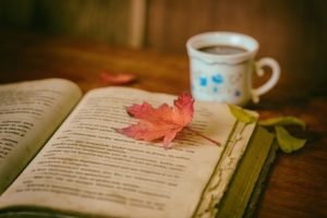 Music: open book with leaf on it and cup of coffee nearby