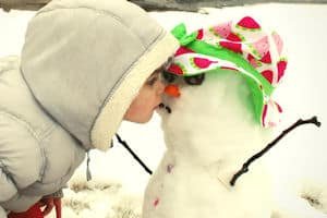 a little girl kissing a snowman...